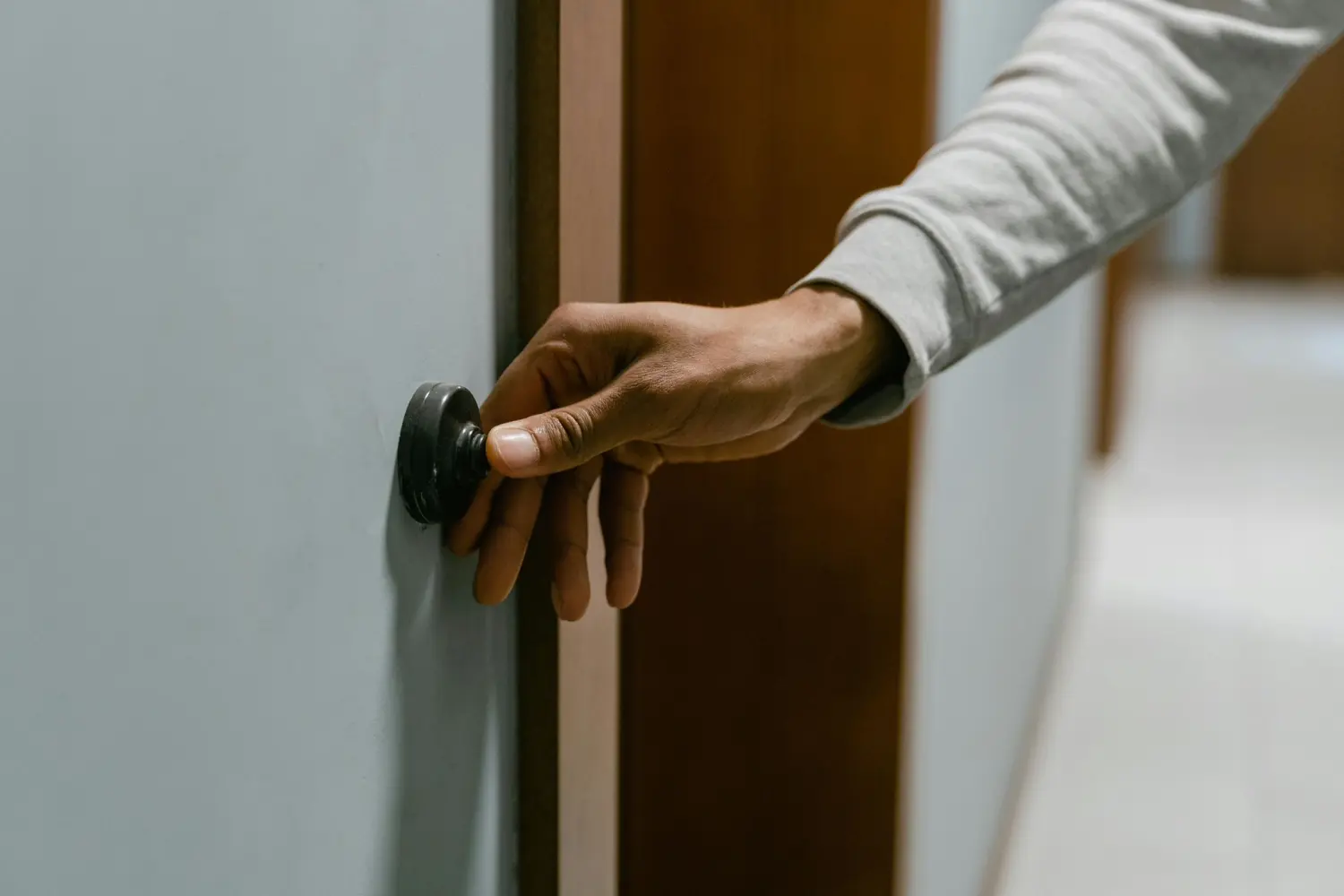 Ergotherapie Obstallee, eine Person drückt den Knopf an der Wand