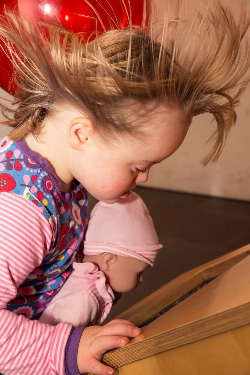 Ergotherapie Obstallee, ein kleines Mädchen mit einer Spielzeugpuppe