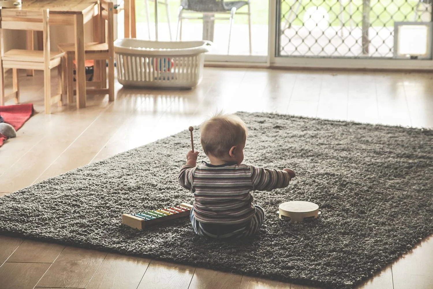 Ergotherapie Obstallee, ein Baby spielt mit Musikspielzeug