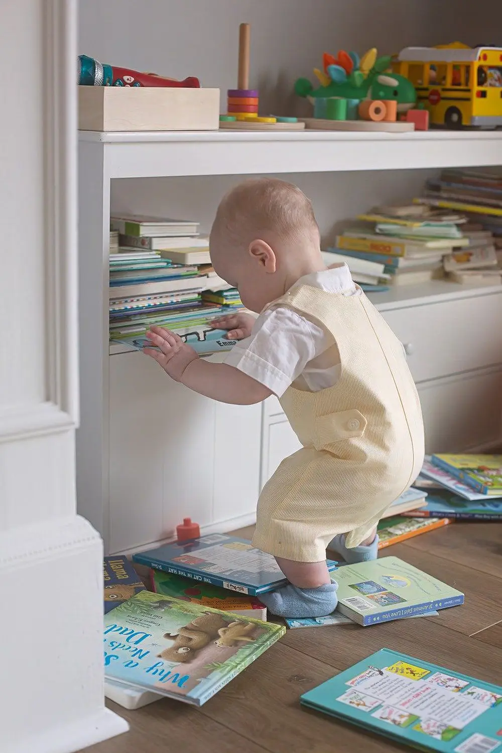 Ergotherapie Obstallee, ein Kind betrachtet die Bücher im Regal und die Bücher auf dem Boden